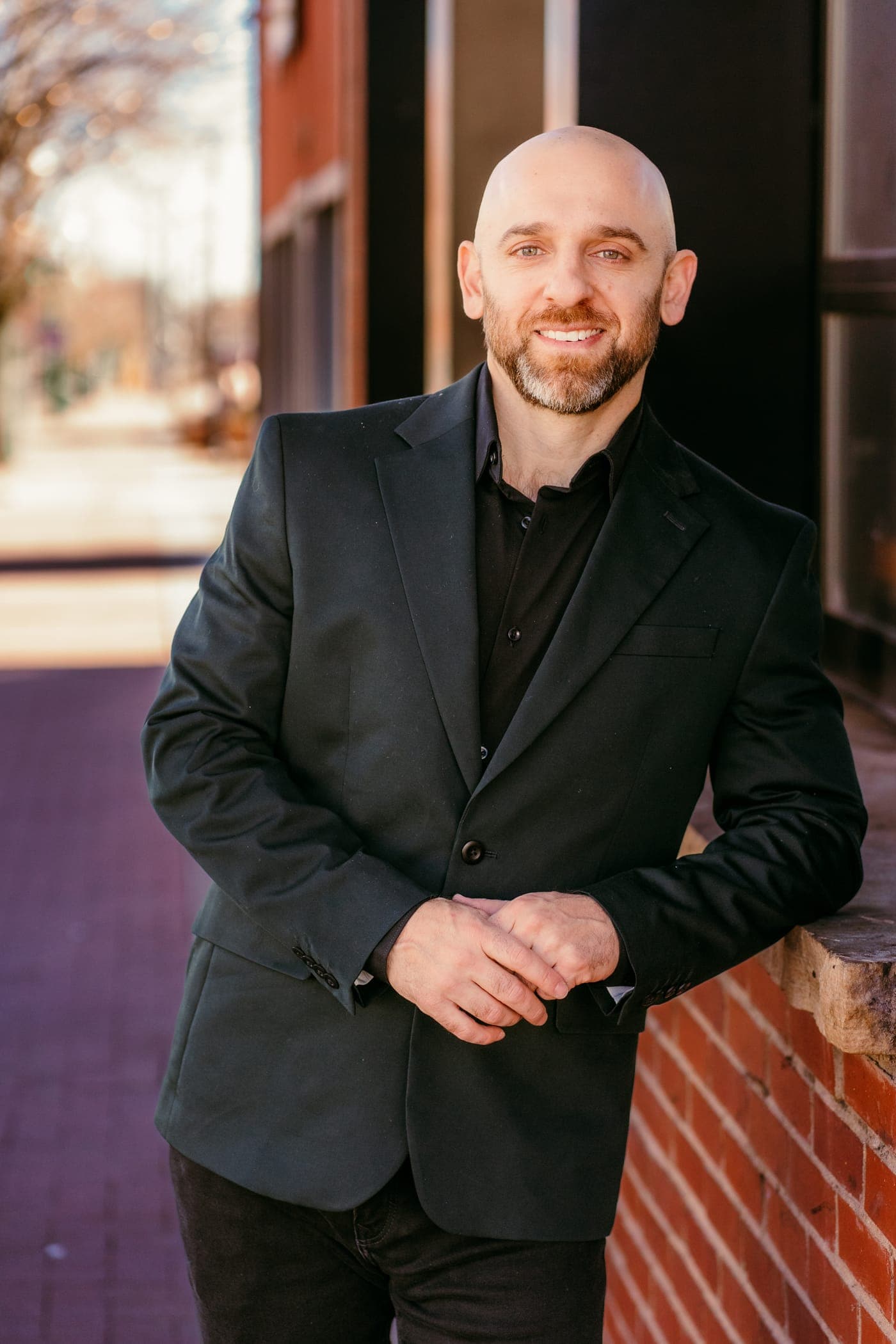 Joey Gindi leaning against a brick storefront in warm Colorado light